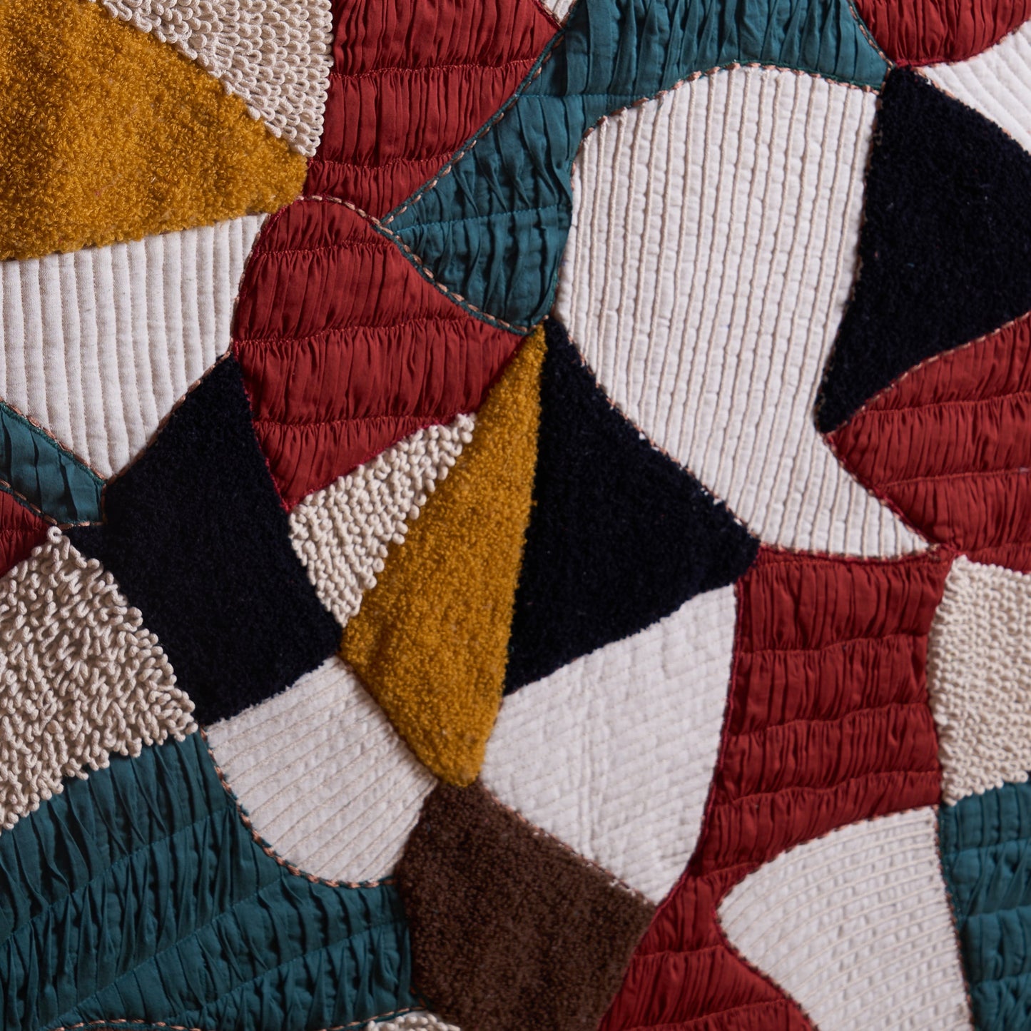 Vliving abstract patchwork textile wall art with teal, red, mustard, ivory, black, and brown textured fabrics.