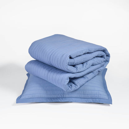 Vliving denim blue quilted bedspread with stripe quilting and border, made of cotton voile. Includes pillow shams.