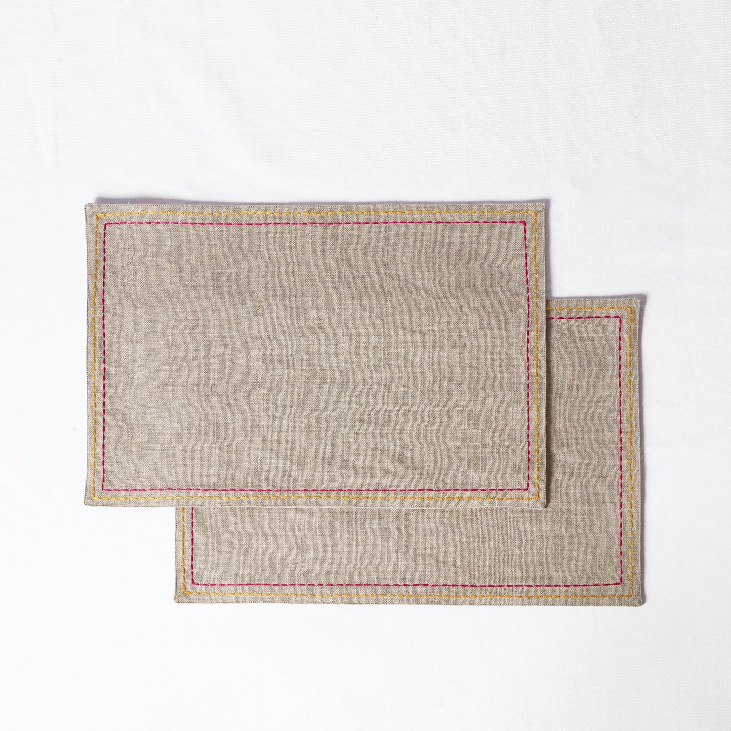 Vliving beige linen placemats with multicolour silk thread embroidery in yellow and pink.