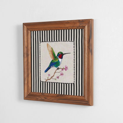 Vliving framed wall art featuring a green hummingbird with red and white accents on a branch with pink flowers, set against a black and white striped background.