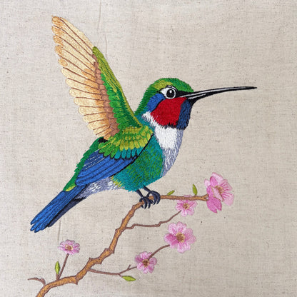 Vliving embroidered hummingbird wall art on linen fabric with pink flowers and a teak wood frame.